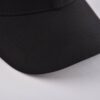 the curved brim of the black and white baseball hat at right side KN2012232